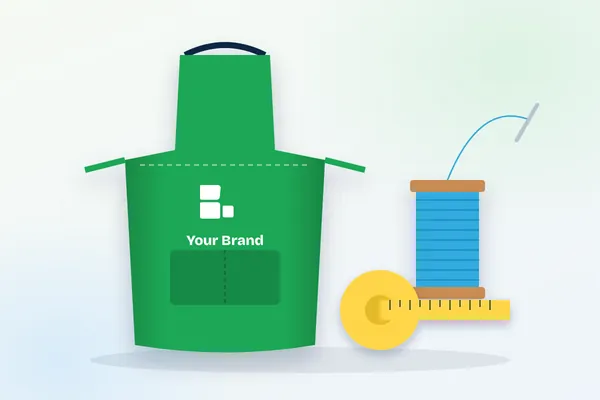 Branded green apron with logo, thread spool and tape measure